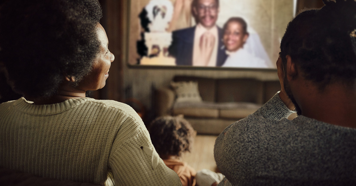 Parents watching their wedding video with their child