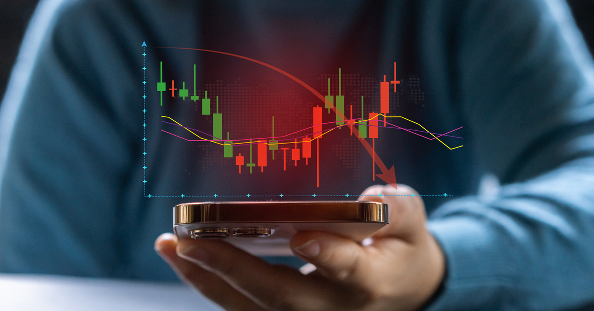 person holding a mobile phone with a graph showing volatility