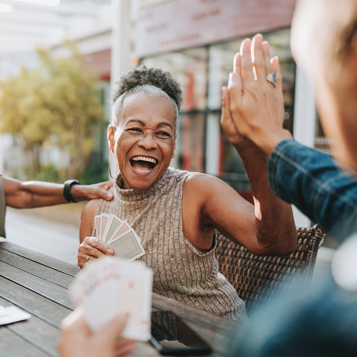 Smiling women high fiving another person.