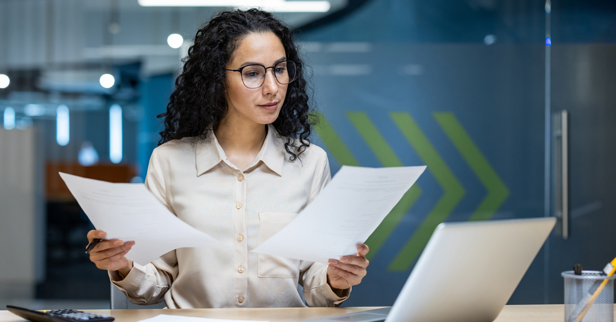 A woman holding two pieces of paper.